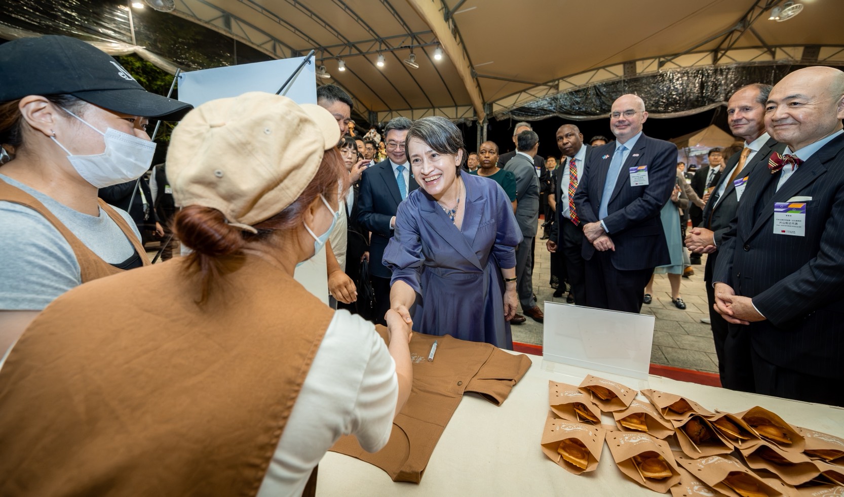 圖說五:蕭美琴副總統(中)、行政院長卓榮泰(後排左一)及使節暨駐台代表團與「魚刺人雞蛋糕」工作人員握手致意。(照片來源:總統府)